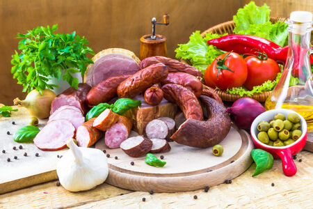 An assortment of meats - sausage and bacon with greenの写真素材