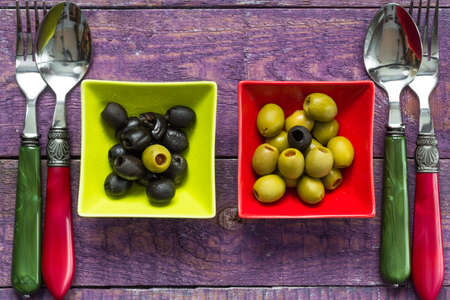 Colorful fruits olives in bowls on wooden tableの写真素材