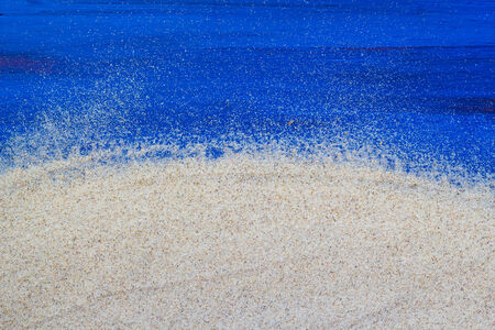 Marine background with sand spilled on a wooden tableの写真素材