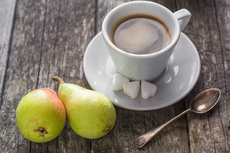 Cup of black coffee on wooden board and pearsの写真素材
