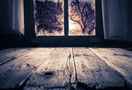 Old rural interior: a window table overlooking the winter eveningの写真素材