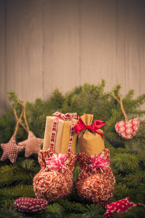 Christmas gifts in handsewn socks. Christmas decorations in the branches of spruceの写真素材