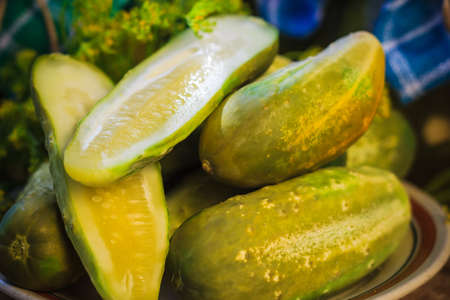 Chopped pickled cucumbers on a plate on a wooden boardの写真素材