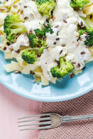 Pasta dish with broccoli and sauce with sunflower seedsの写真素材