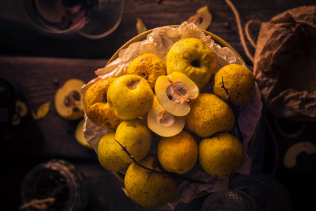 Fruits and twigs quince on a wooden tableの写真素材