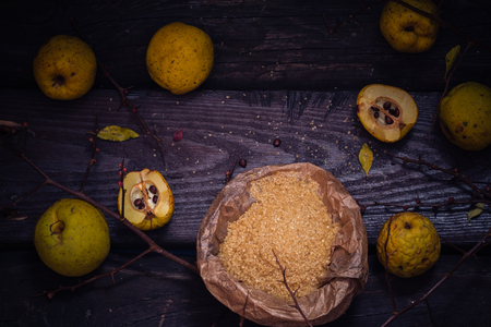 Fruits, twigs quince, sugar on a wooden tableの写真素材