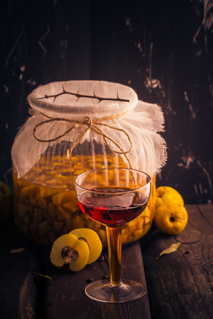 Tincture in a cup and sliced fruit quince in a jar covered with sugarの写真素材