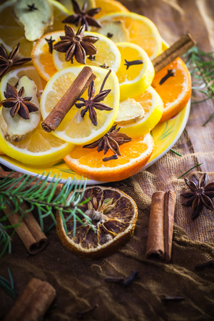 Ingredients for medicinal tea. Citrus and spices. Slices of lemon, orange, ginger, cloves and cinnamon.の写真素材