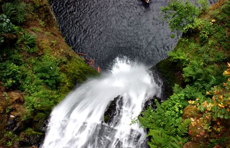 a waterfall that is shown going down to the lakeの写真素材