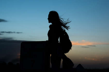 Young woman silhouette in a sunsetの写真素材