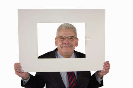 A smiling senior caucasian businessman holding a photo mount with copy space, isolated on white backgroundの写真素材