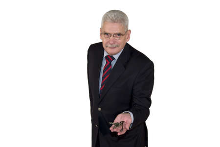 A smiling senior caucasian manager offering a key, isolated on white backgroundの写真素材