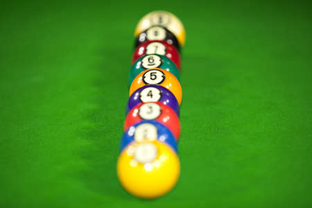 Nine billiard balls on a billiard table lying in a row