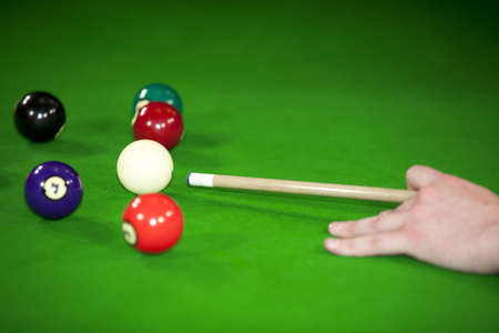 A billiard game situation with the billiard player being ready to hit the white ball to shoot it...