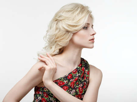 Beauty portrait of a beautiful blonde in a black dress with red rosesの写真素材