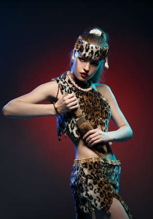 Girl in clothes Amazons with a knife in his hand. Studio photography.の写真素材