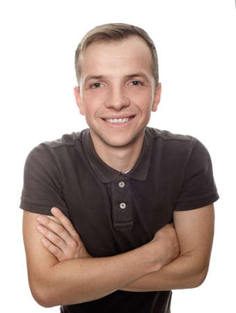 A young man with a smile, standing with arms crossed on a white background. Isolated.