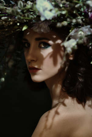Beautiful girl with a wreath on his head. Forest Fairy. Shallow depth of field.の写真素材