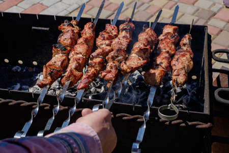Preparation of shish kebabs outdoors. Lunch in a country house. Picnic in weekend. Barbecues on the grill.の写真素材