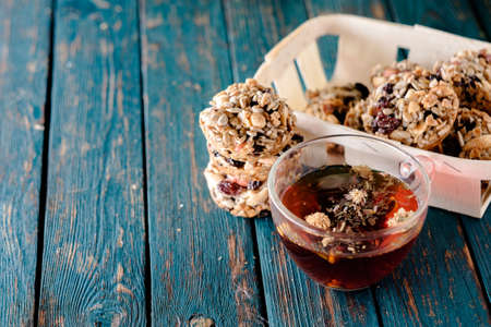 Cup of tea and cookies made of nuts and raisins on the blue wooden table. Kozinaki.の写真素材