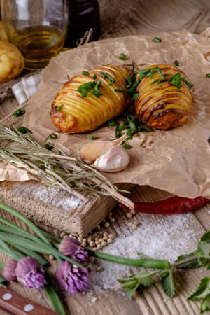 Sliced baked potatoes over wooden background. Rustic style.の写真素材