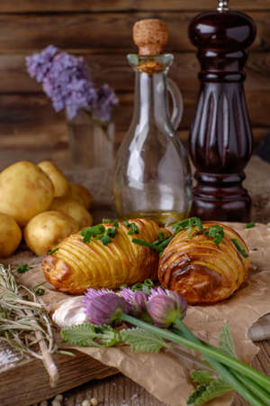 Sliced baked potatoes over wooden background. Rustic style.