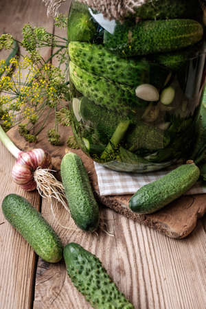 Jar of pickles on wooden table. Salted Cucumbers still-life.の写真素材