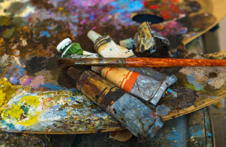 Tubes of paint on a palette for mixing oil paints. Creative mess. The color palette close up.の写真素材