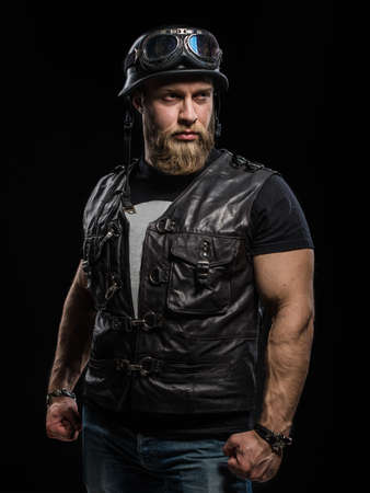 Portrait Handsome Bearded Biker Man in Leather Jacket and Helmet over Black Backgroundの写真素材