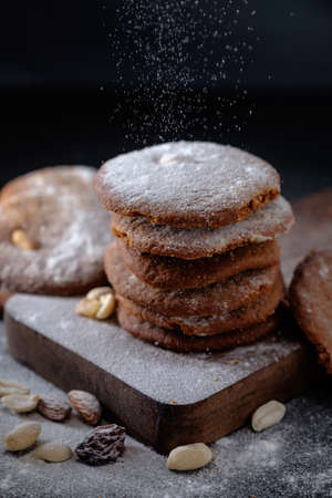 Gingerbread cookies dusted with icing sugar on a wooden table.の写真素材