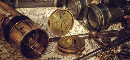 Old vintage retro compass and spyglass on ancient world map. Vintage still life.の写真素材