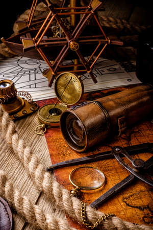 Old vintage retro compass and spyglass on ancient world map. Vintage still life. Travel geography navigation concept background.の写真素材