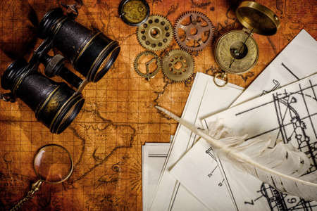 Old vintage retro compass and binoculars on ancient world map. Vintage still life. Travel geography...