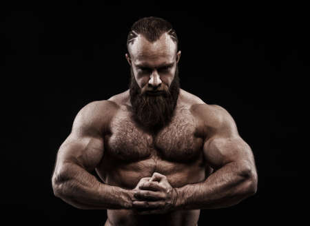 Strong man with perfect abs, shoulders, biceps, triceps and chest. Bodybuilder topless over black...