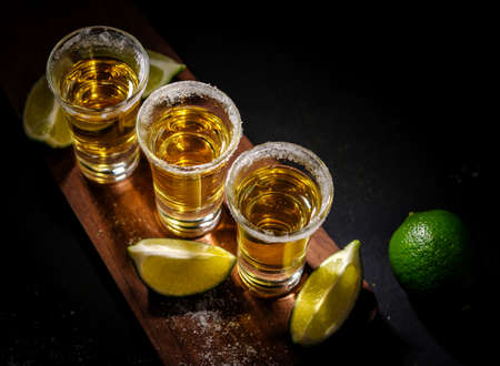 Mexican Gold Tequila with lime and salt on wooden background, selective focus. Top view.の写真素材
