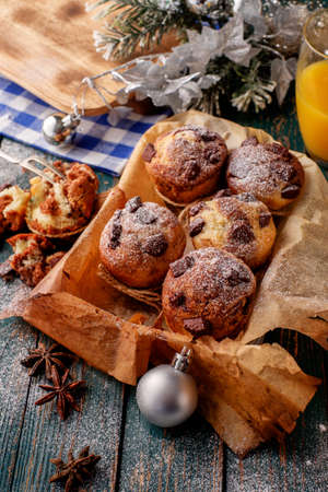 Chocolate muffins with powdered sugar on the wooden table, rustic style. New Year's Concept.の写真素材