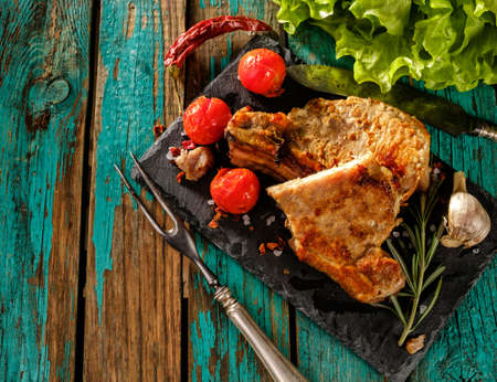 Juicy steak well done pork with tomatoes and herbs