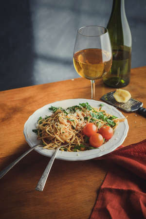 Spaghetti with cherry tomartoes served on a wooden tableの写真素材