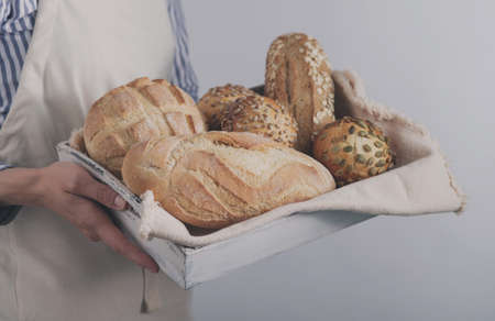 Baker's hands hold fresh bread.