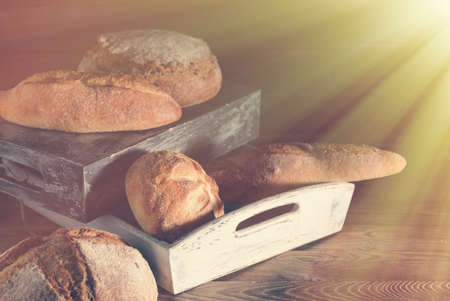 Different kinds of bread on wooden table.の写真素材