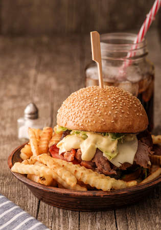 Freshly cooked homemade burger with chopped beef, cheese and fresh herbsの写真素材