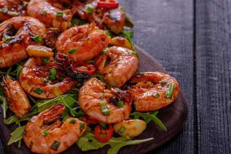Large grilled BBQ shrimp with sweet chili sauce, green onion and lemon. Copyspace.の写真素材