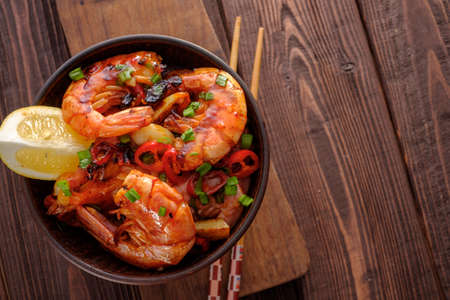 Large grilled BBQ shrimp with sweet chili sauce, green onion and lemon, copyspace.の写真素材