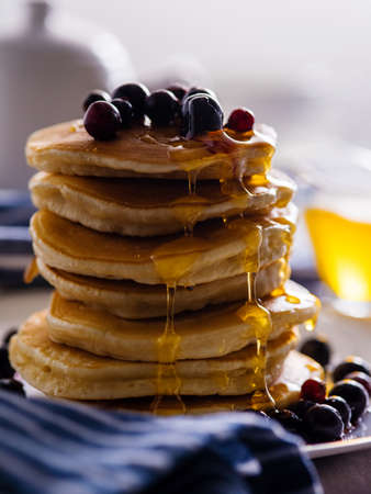 Pancakes with berries and honey on a light background.の写真素材