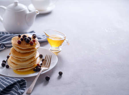 Pancakes with berries and honey on a light background.の写真素材