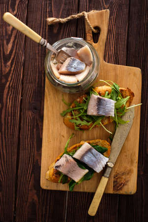 Herring sandwich (traditional Danish smorrebrod) on cutting board. Top view.の写真素材