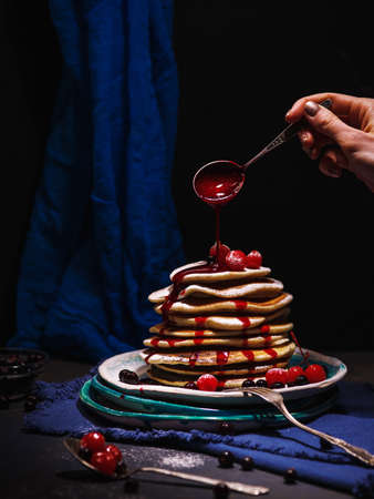 Pancakes with berries and jam on a dark background.の写真素材