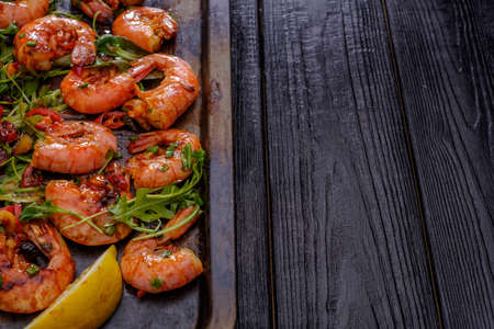 Large grilled BBQ shrimp with sweet chili sauce, green onion and lemon, copyspace.の写真素材