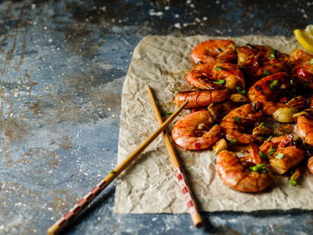 Large grilled BBQ shrimp with sweet chili sauce, green onion and lemon, Copyspace.の写真素材