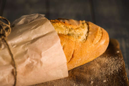 A fresh baguette on a wooden surface. Shallow depth of field.の写真素材